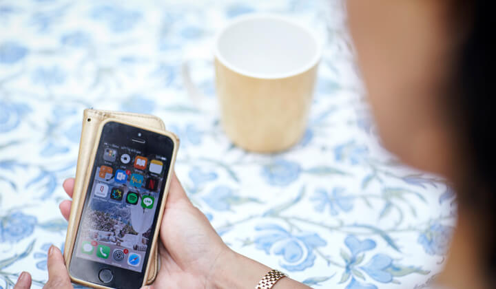 In focus image of a mobile phone in a woman’s hand.